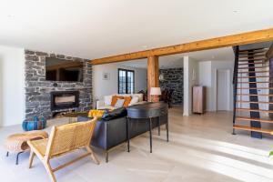 een woonkamer met een bank en een stenen open haard bij Villa Horizonte Azul by Holiday Rental Madeira in Ponta do Sol