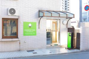 um edifício com um sinal na lateral em FLEXSTAY INN Nakanobu em Tóquio