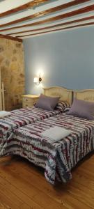 a bedroom with a bed with a blanket on it at Hotel Rural el Arrabal Siguenza in Sigüenza