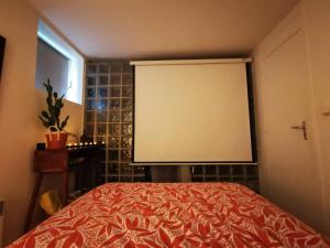 een groot scherm in een kamer met een bed bij Loft Paris Beach + extérieur #Jacuzzi #Barbecue in Fontenay-sous-Bois