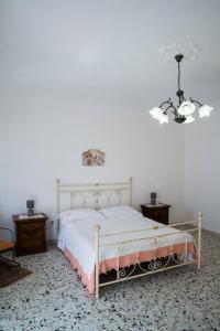 a bedroom with a bed and a chandelier at La casetta di Anna in Palazzolo Acreide