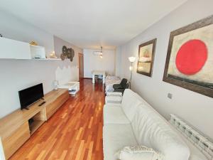 a living room with a white couch and a tv at Agora Apartments in Lleida