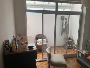 a living room with a table and a glass door at excelete departamento en el centro de Martinez in Martínez