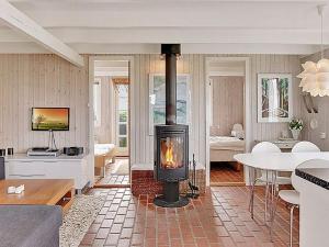 a living room with a wood stove in a room at 4 person holiday home in Harbo re in Harboør