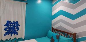 una camera da letto con parete a righe blu e bianche di Auberge bouloulou a Bouéni