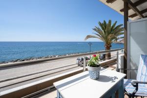 una mesa con una planta en un balcón con vistas al océano en Maria's Hotel, en Palaiochóra