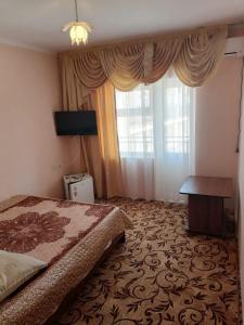 - une chambre avec un lit et une grande fenêtre dans l'établissement Guest House Emiliya, à Yakornaya Shchel'
