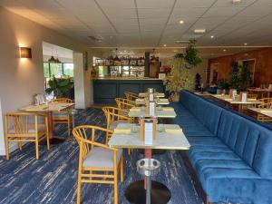 rzędu stołów i krzeseł w restauracji w obiekcie Artémis Hôtel & Spa Bistro Coquet w mieście Brioude