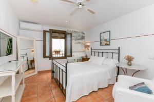 a bedroom with a white bed and a couch at La Morada Mas Hermosa in Marbella