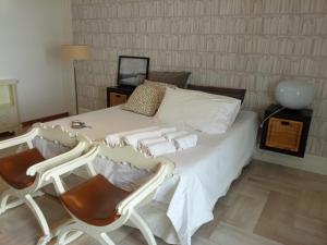 1 Schlafzimmer mit einem weißen Bett mit 2 Stühlen in der Unterkunft Dante 26 in Alberobello