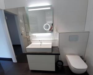 ein weißes Bad mit einem Waschbecken und einem WC in der Unterkunft Ihr Ticket ins Grüne - Topmoderne 5-Sterne-Ferienwohnung in Bad Kreuznach