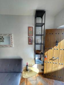 Habitación con sofá, mesa y estante en Casita Beatriz - by Casa del Patio, en Estepona