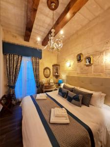 a bedroom with a large bed with a chandelier at Casa Asti in Valletta