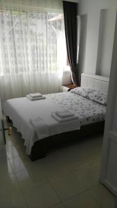 a bedroom with a white bed with a window at Uysal Suite and Loft Seaside in Marmaris