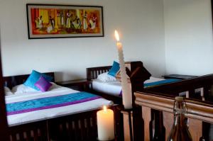 a room with two beds with a candle and a candle at Sir John's Bungalow in Matale +28 photos