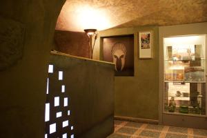 a hallway with a lamp and a wall with a sculpture at Hotel U Kříže in Prague