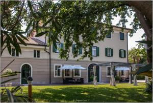 un grande edificio con tavolo e ombrellone all'aperto di Villa Rigatti a San Valentino