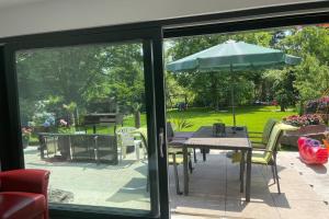 a patio with a table and an umbrella at Wunderschöne Terrassenwohnung mit Blick ins Grüne! in Meerbusch