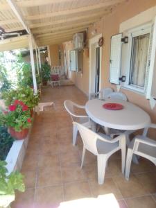 a patio with a white table and chairs at Villa Angela, Traditional Villa in the village in Agios Ioannis Peristerion