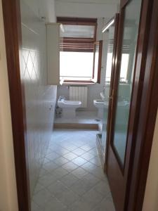 ein Bad mit einem Waschbecken, einem WC und einem Fenster in der Unterkunft Dante 26 in Alberobello