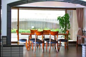 una mesa de comedor y sillas con una gran ventana en FLEXSTAY INN Shinurayasu, en Urayasu