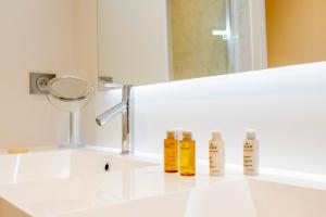 a bathroom with a white sink with two bottles on it at Résidence Les Suites du Port in Arcachon