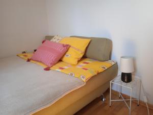 a bed with colorful pillows on it with a table at Apartment Mimi in Opric
