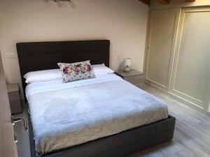 1 dormitorio con 1 cama grande y cabecero negro en Stanza privata con bagno Contrada Covile, en Bosco Chiesanuova