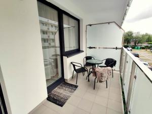 balkon ze stołem i krzesłami w obiekcie Apartament Słoneczny Brzeg w Kołobrzegu