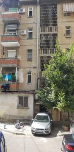 Srebrny samochód zaparkowany przed budynkiem w obiekcie Spacious and Cozy Apartment - Ajia Apartment w Tiranie