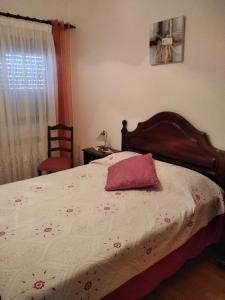Dormitorio con cama con almohada rosa en calmo e simpatico apartamento, en Vila Praia de Âncora