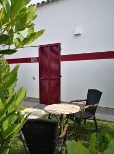 a table and chairs in front of a building with a red door at Country House La Cipolla D'oro in Potenza Picena