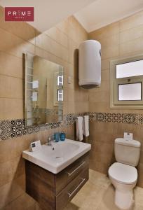 uma casa de banho com um lavatório, um WC e um espelho. em Prime Select Point 90 Mall em Cairo