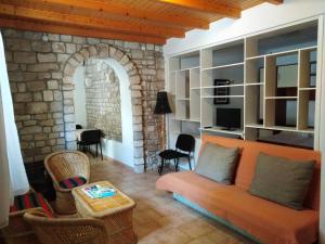 ein Wohnzimmer mit einem Sofa und einer Steinmauer in der Unterkunft Apartment Bibić - Hvar center old town in Hvar