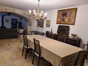 uma sala de jantar com uma mesa e cadeiras e um lustre em Casa do Armador em Setúbal