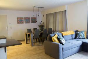 a living room with a blue couch and a dining room at 'T ONDERDAK in Lommel