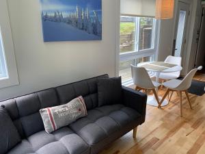 a living room with a couch and a table at The MountainSide by Escapades Tremblant in Mont-Tremblant