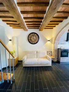 un soggiorno con divano bianco e orologio sul muro di Ca' di Leo a Santa Fiora