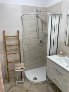 a bathroom with a shower with a chair and a sink at casa Belcolle in Putignano +17 photos