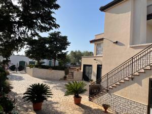 a house with potted plants next to a building at casa Belcolle in Putignano