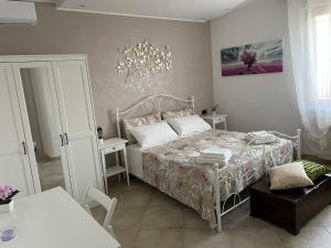 a bedroom with a bed and a table and a chair at casa Belcolle in Putignano