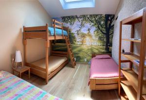 a bedroom with bunk beds with a mural of a forest at La Malinette bio B&B, calme et authenticité in Mâlain