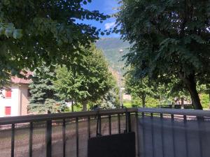 a bench next to a fence with trees and a mountain at Appartement cosy proche de la gare in Saint-Jean-de-Maurienne