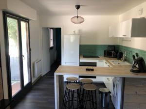 a kitchen with a counter and stools in it at Appartement cosy proche de la gare in Saint-Jean-de-Maurienne