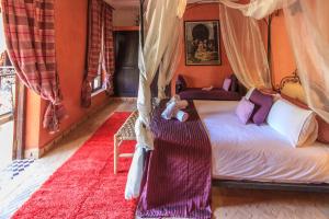 Un dormitorio con cama con dosel y un osito de peluche. en Riad Nabila, en Marrakech