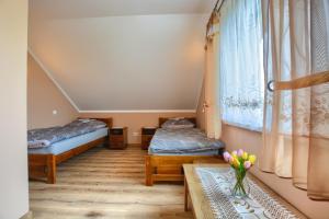 ein Zimmer mit zwei Betten und einem Tisch in der Unterkunft Domek letniskowy Elizjum in Myczków