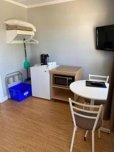 a small kitchen with a table and a table and a refrigerator at Motel Glenn in Perce