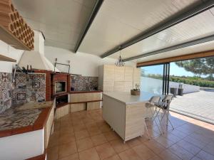 a kitchen with a counter and a large window at Quinta Foz Arelho Piscina Aquecida in Foz do Arelho