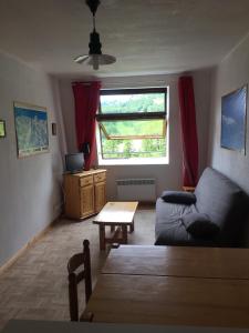 a living room with a couch and a table at Studio montagne in Allos