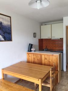 a kitchen with a wooden table in a room at Studio montagne in Allos